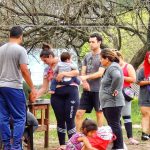 A group of people standing around a soccer goal